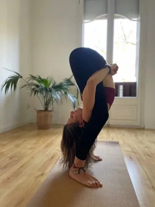Practicante en una flexión de pie en una sala luminosa