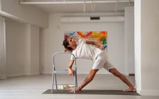 Práctica de Iyengar con silla en una sala luminosa