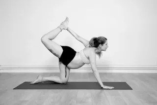 Mujer embarazada practicando yoga en blanco y negro
